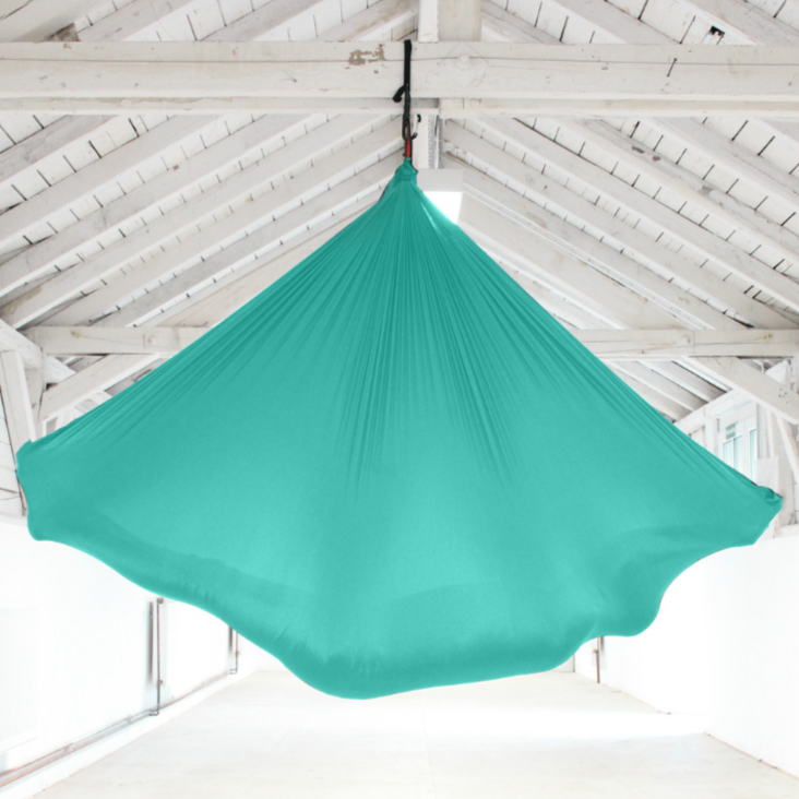 Aerial Yoga Tuch in Türkis hängend im Raum von Yogalaxy
